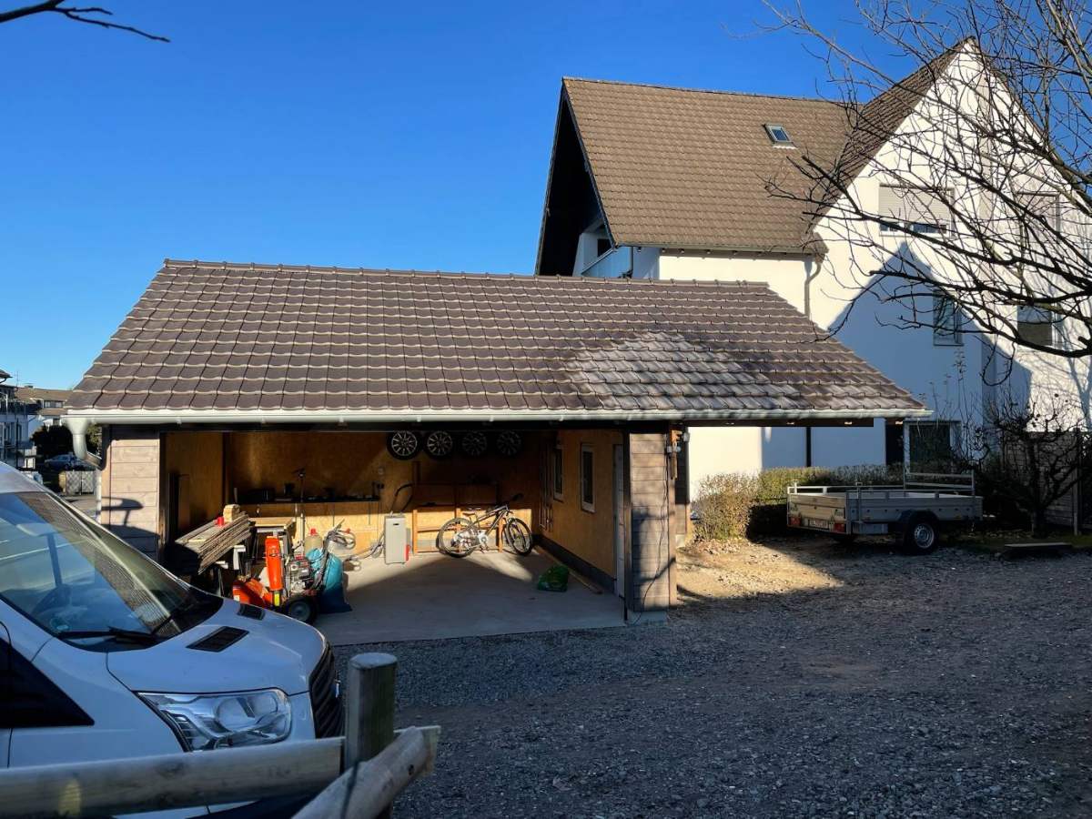 Carport aus Holz mit Satteldach an einem Einfamilienhaus