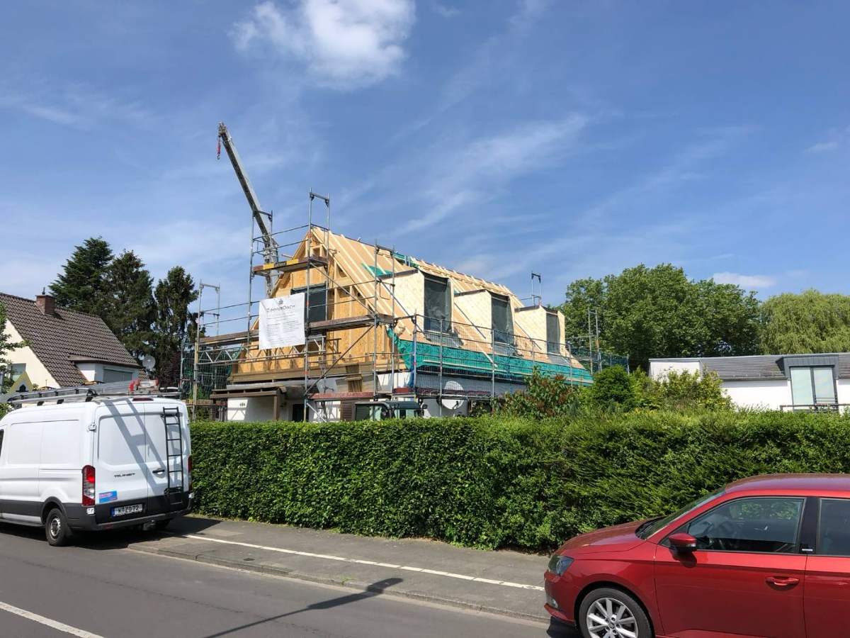 Dachaufstockung mit Baukran in einer Wohnstraße
